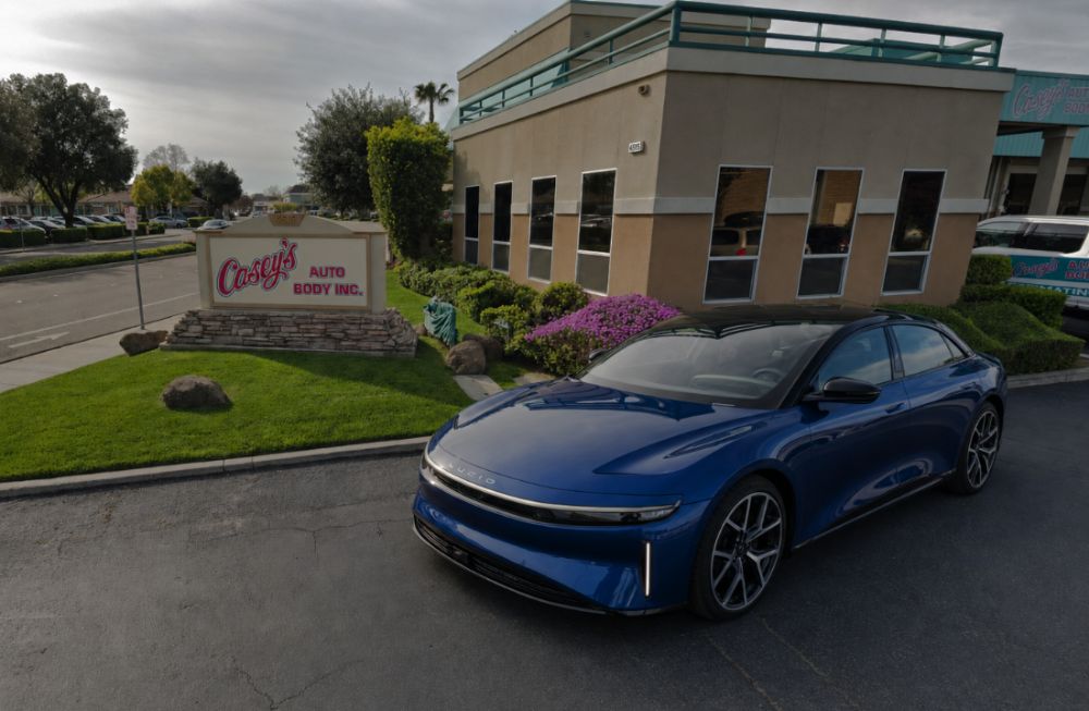 Lucid Air in Blue sitting in front of Casey's Auto Body an Alioto's Auto Body shop Brentwood
